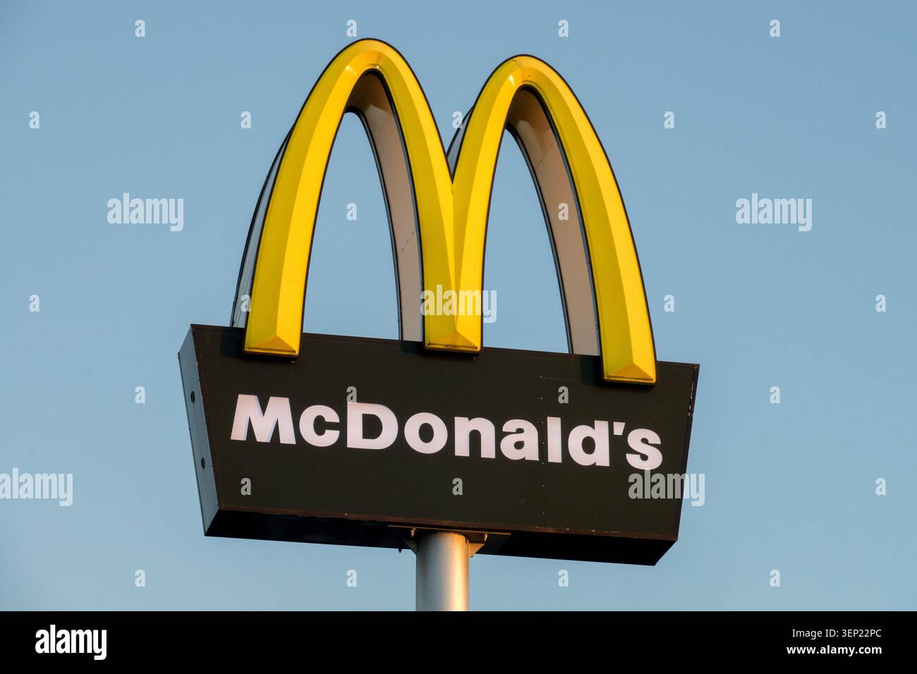 Segno giallo e nero con il logo del McDonalds contro un cielo blu Foto Stock