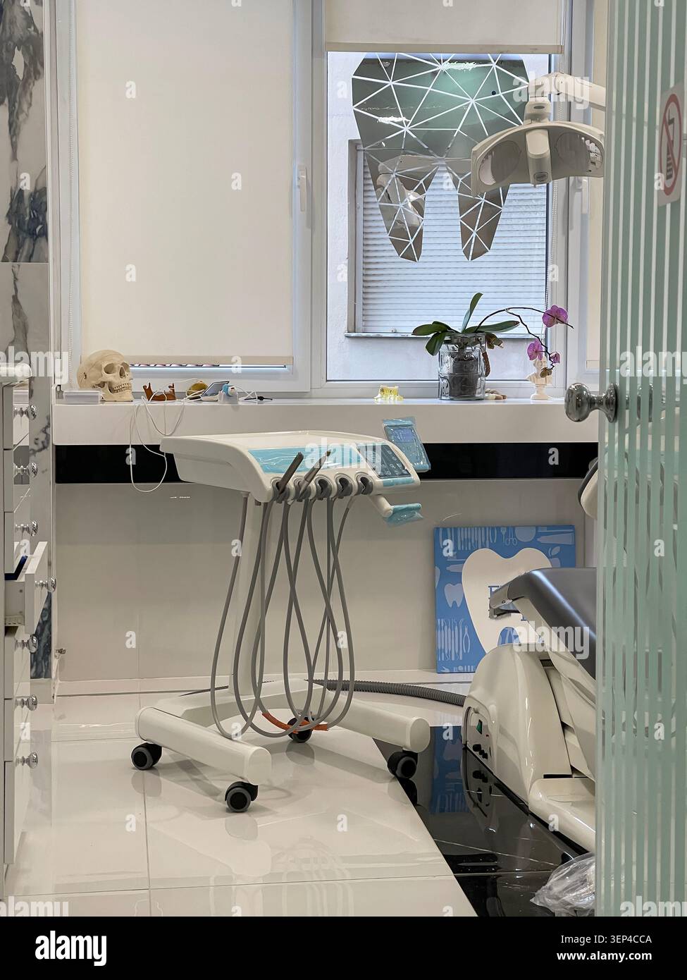 Interno moderno di una clinica dentale con sedia per trattamenti e attrezzature mediche professionali. - Immagine stock catturata con smartphone