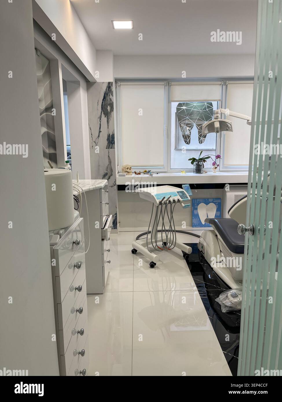 Interno moderno di una clinica dentale con sedia per trattamenti e attrezzature mediche professionali. - Immagine stock catturata con smartphone