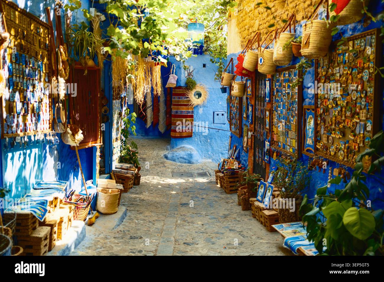 Strada blu di Chefchaouen con tappeti appesi alle pareti Foto Stock