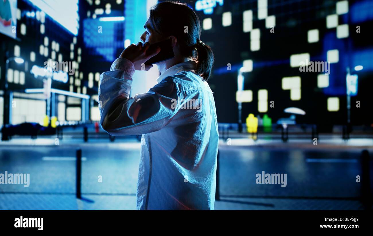 Uomo che passeggiava per il paesaggio urbano di notte, conversava al telefono con gli amici, uomo d'affari che torna a casa dal lavoro e telefona per rendere il viaggio più piacevole. Foto Stock