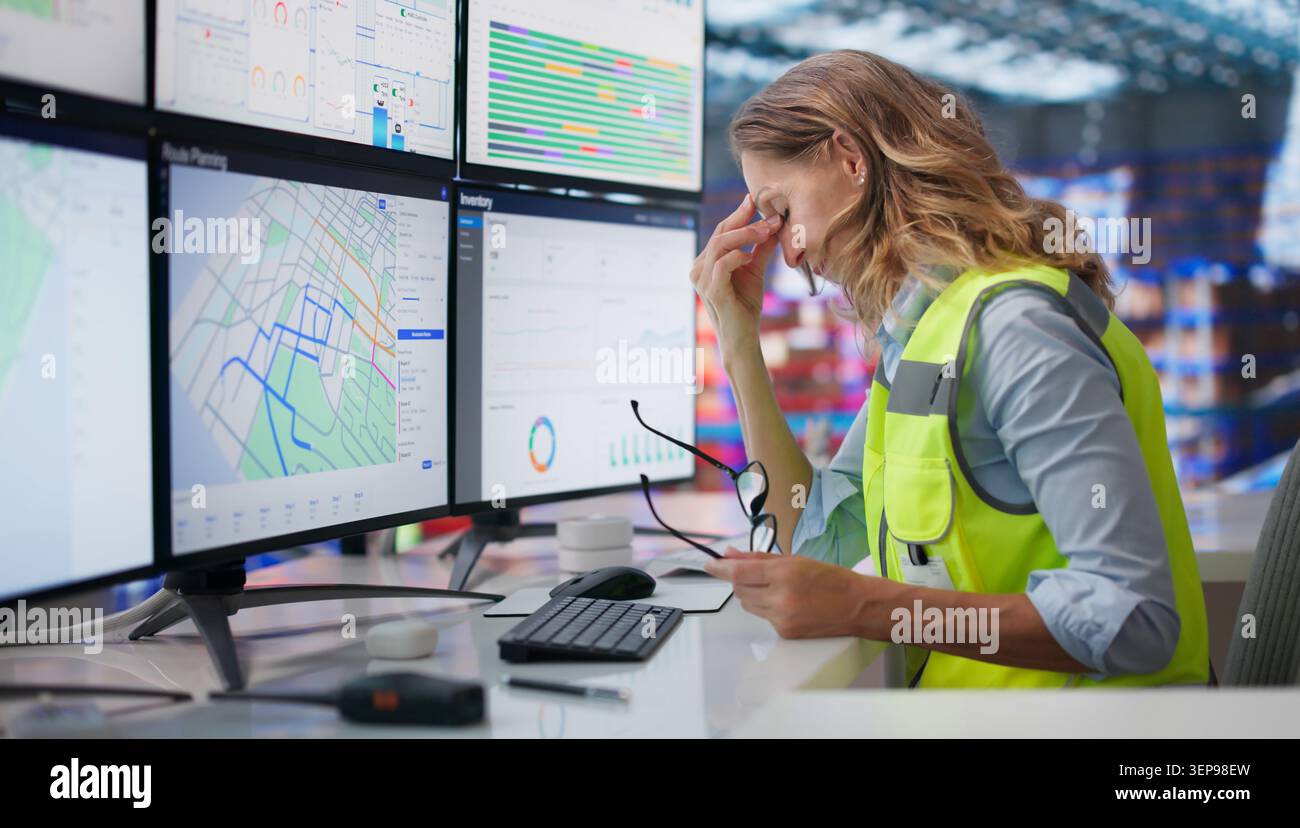 Donna con gli occhi stanchi che fissa lo schermo del computer dopo un lungo lavoro turno. Foto Stock