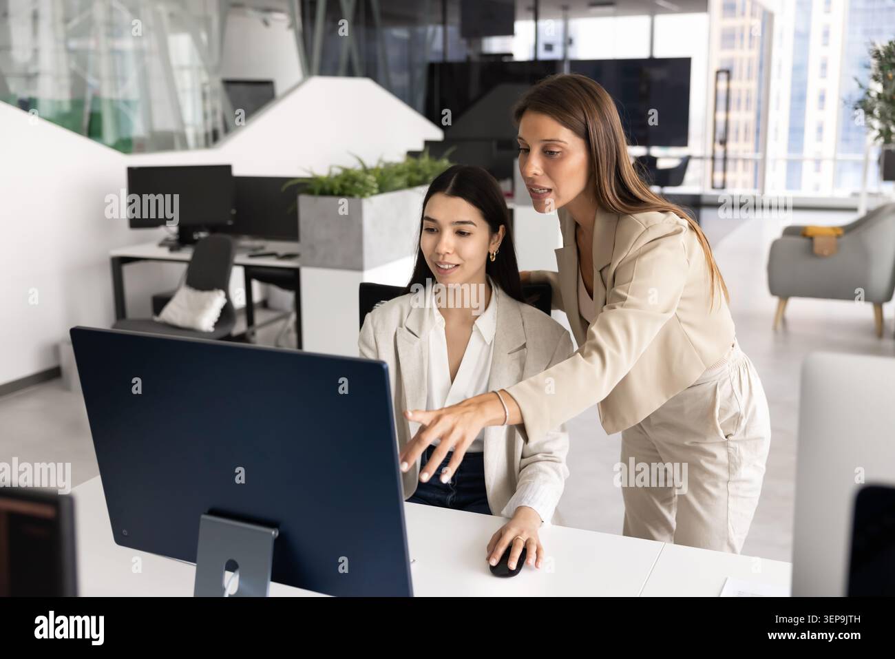 Coach donna che fornisce spiegazioni sul programma o sul software ai colleghi Foto Stock