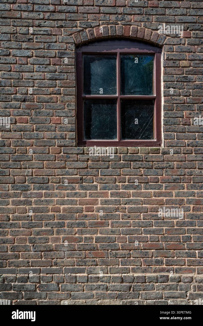 Vecchia finestra a quattro pannelli incastonata in mattoni storici presso il Red House Glass Cone di Stourbridge, che mostra l'architettura storica e i dettagli testurizzati Foto Stock