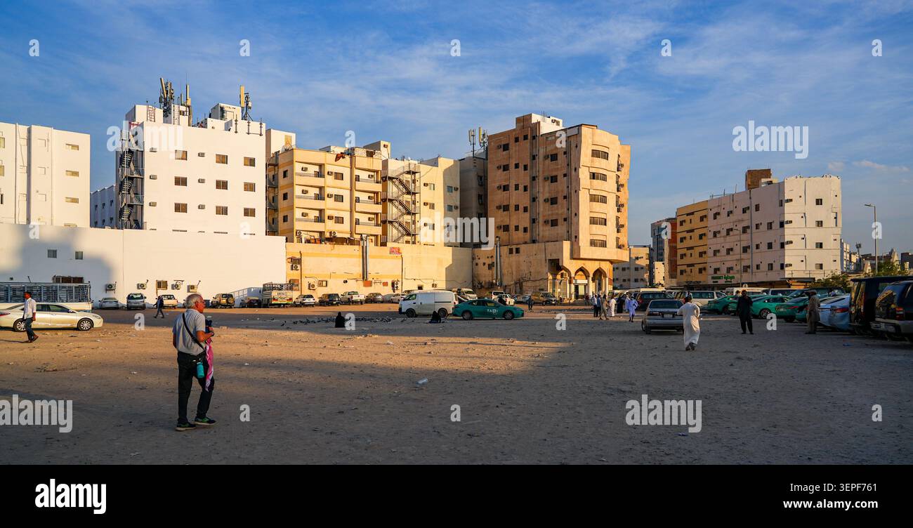 Un parcheggio polveroso e sterrato circondato da condomini a Madinah, Arabia Saudita Foto Stock