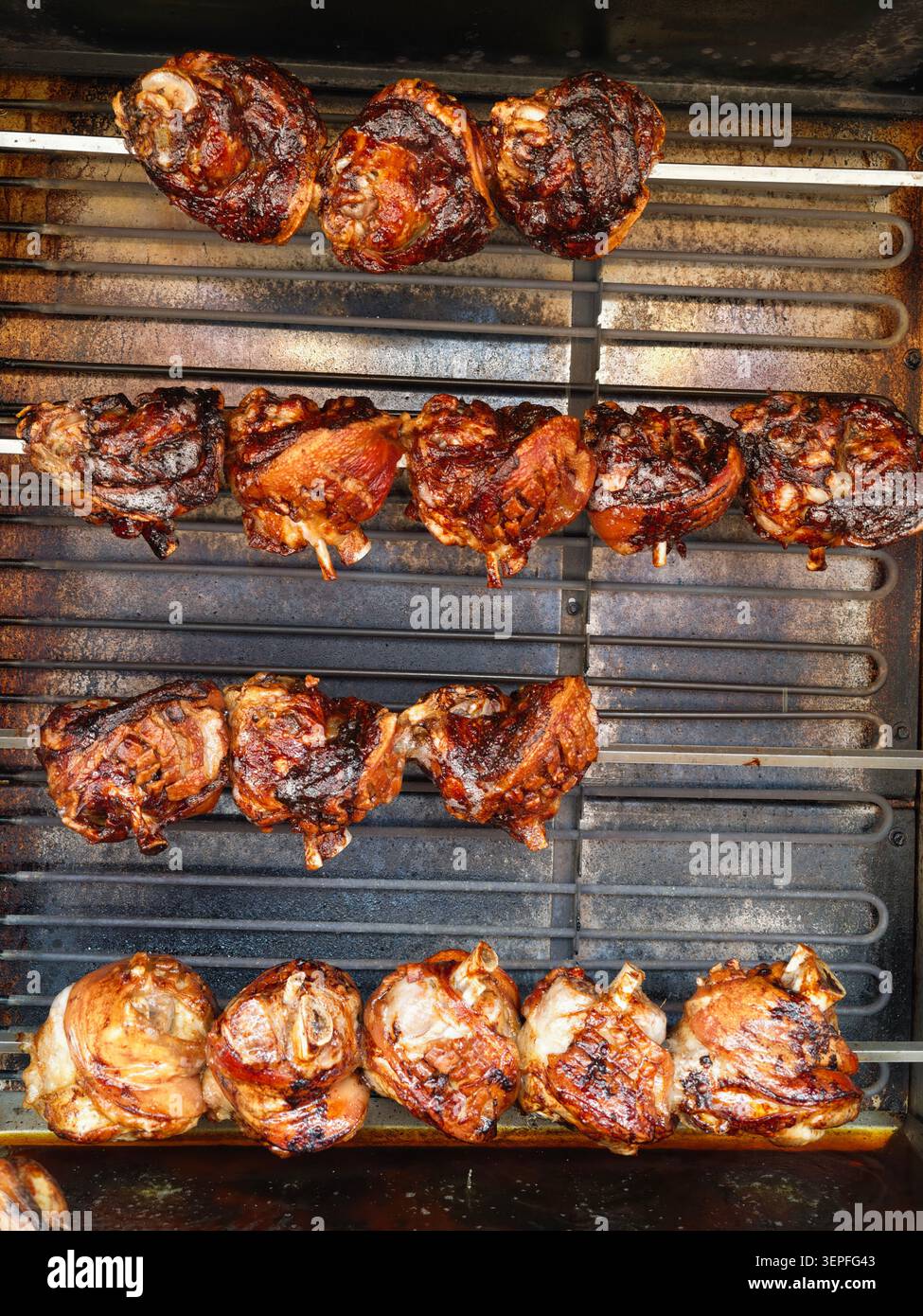 Pforzheim Germania - 14 giugno 2026 vista ravvicinata di spiedini di carne conditi disposti in file su griglia metallica all'interno di un forno per barbecue. La carne p Foto Stock