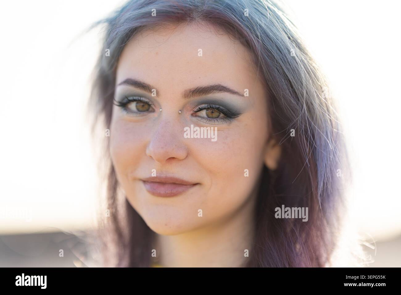 Giovane donna sorridente con capelli dai colori unici e piercing facciale Foto Stock