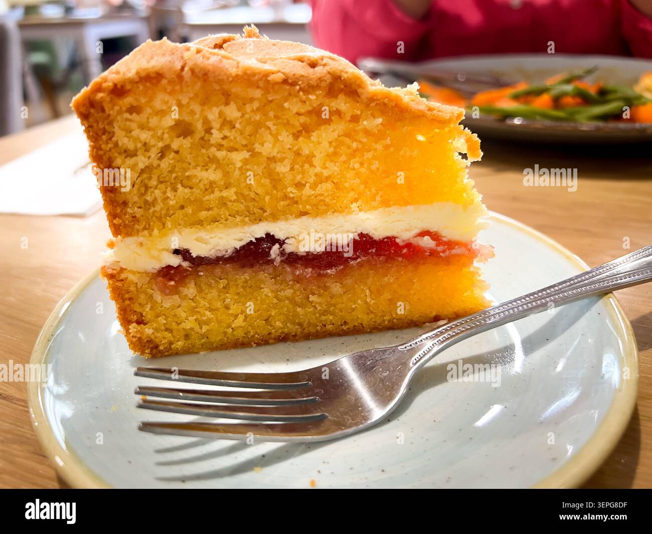 Una fetta di torta Victoria Sponge, due strati di spugna per torte intorno a uno strato di glassa di burro e marmellata Foto Stock