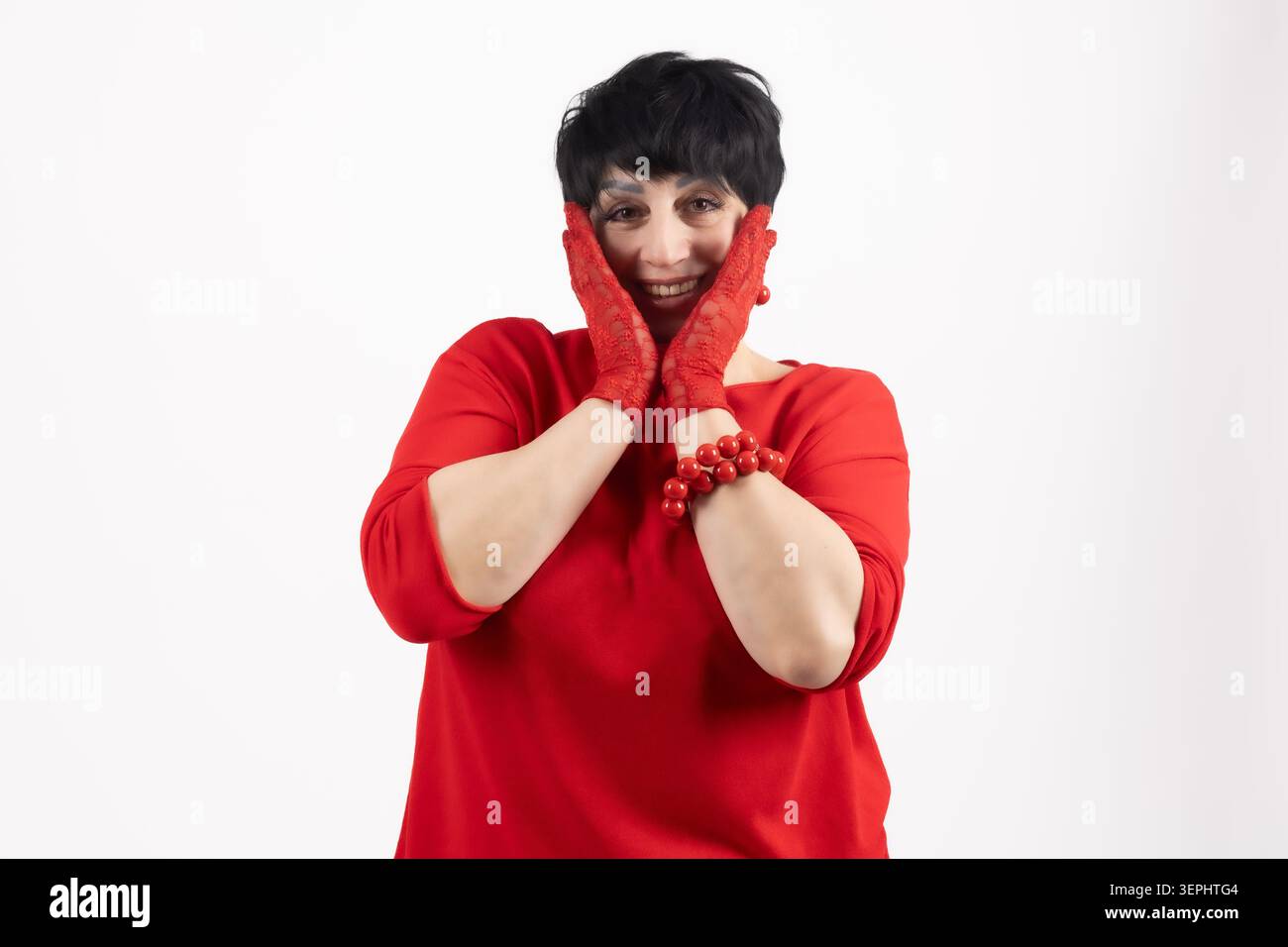 Una donna allegra e di grandi dimensioni che si tocca le guance con le mani sorridenti Foto Stock