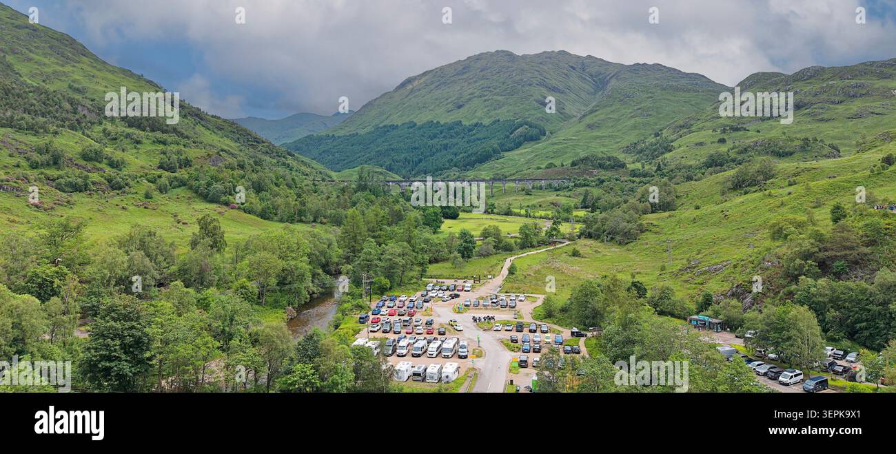 Il treno a vapore Jacobite Glenfinnan Viaduct Scotland Community e i parcheggi del National Trust sono pieni di capacità Foto Stock