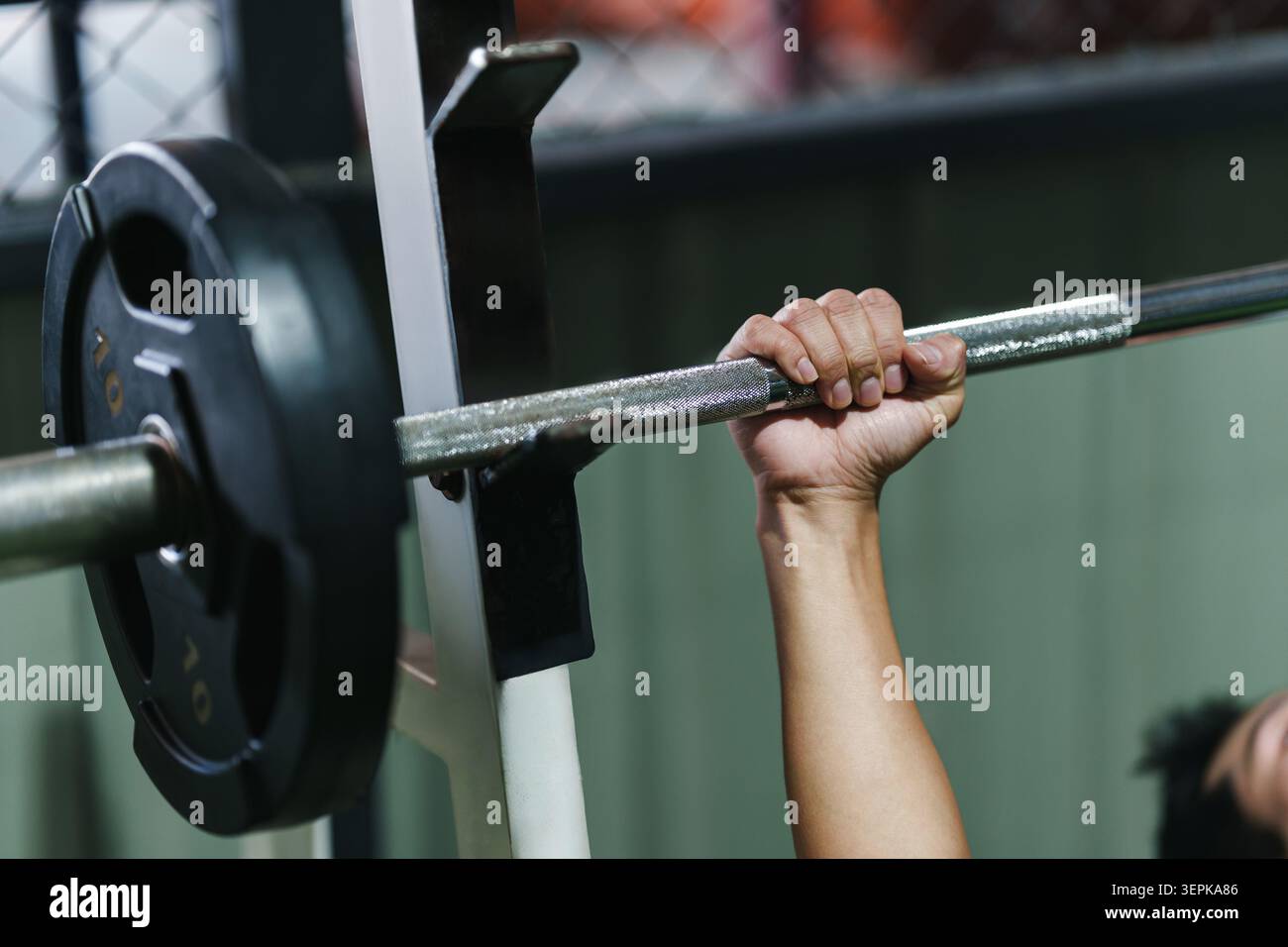 Barcampanello corto e impugnabile con pesi su rack nella moderna palestra per il sollevamento pesi e l'allenamento muscolare Foto Stock