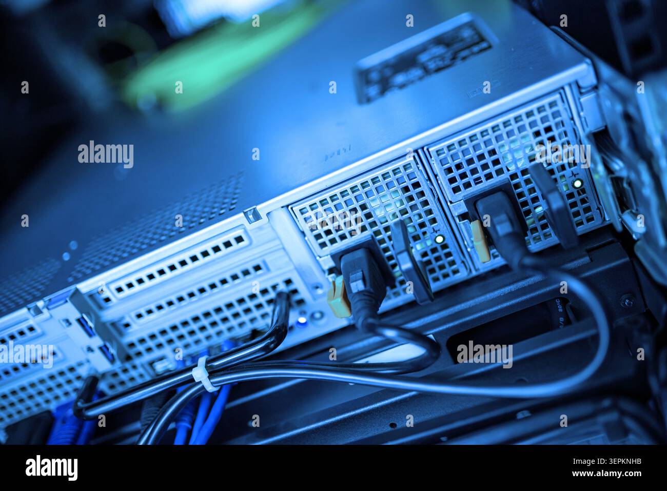 Questa immagine mostra un primo piano di un server rack in un data center con più unità hardware collegate tramite cavi di rete, evidenziando la gestione dei dati A. Foto Stock