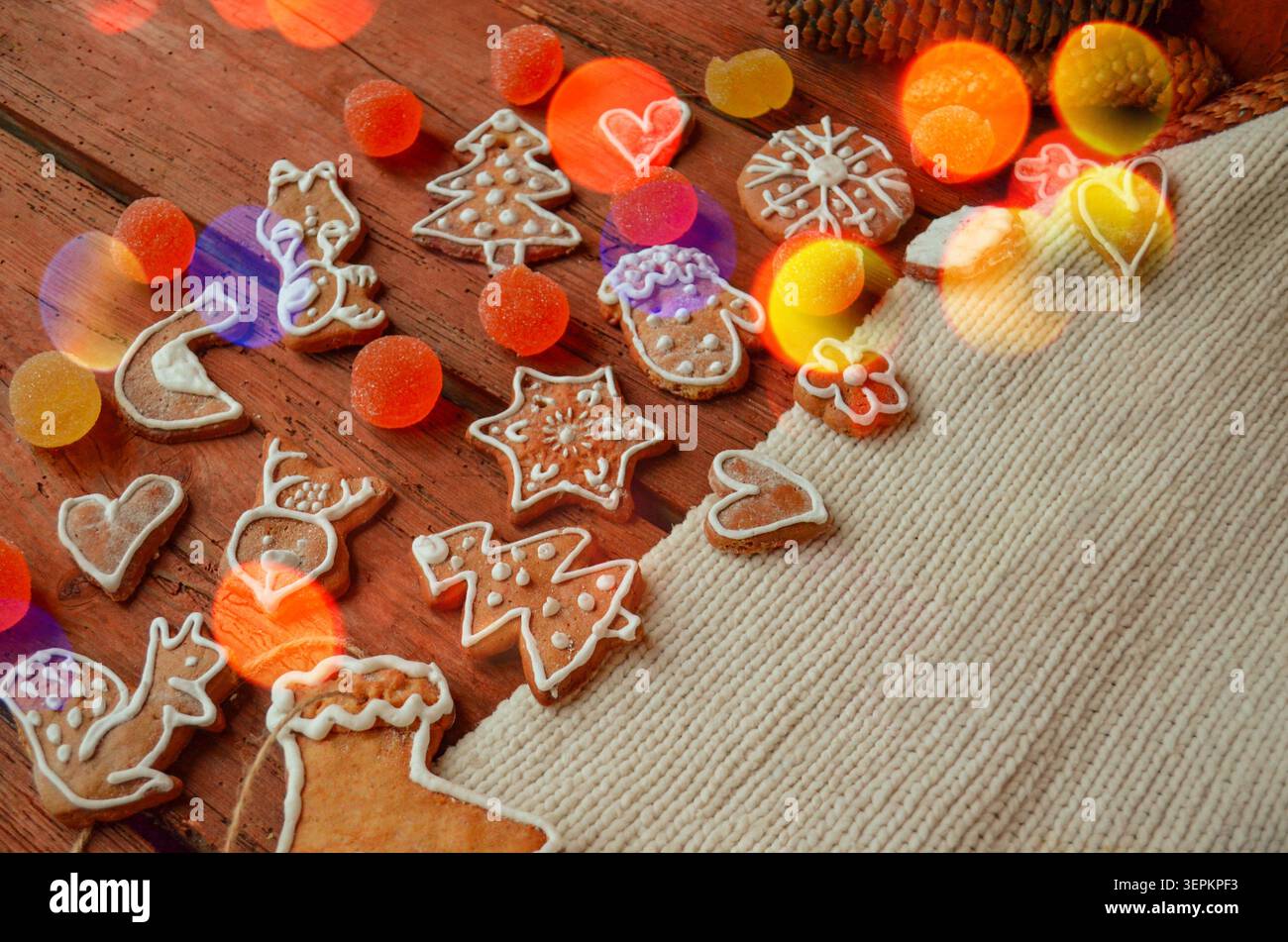 Delizioso sfondo natalizio con pan di zenzero, cannella e spezie. Forme di pan di zenzero disposte in una disposizione organica. Biscotti di Natale fatti in casa su legno Foto Stock
