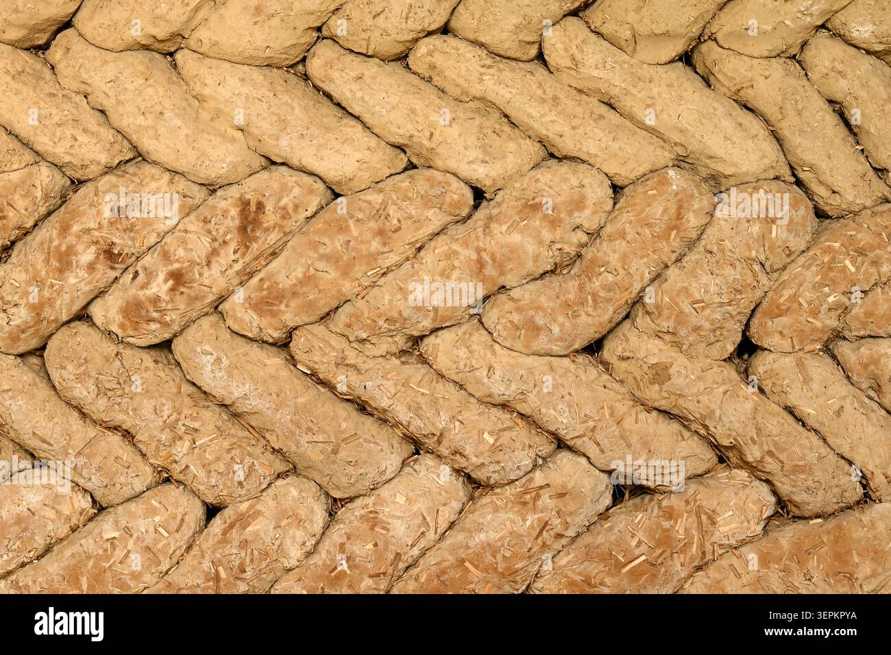 Sfondo di rustiche pareti in mattoni di fango di adobe con struttura in paglia e costruzione in terra a motivi geometrici Foto Stock