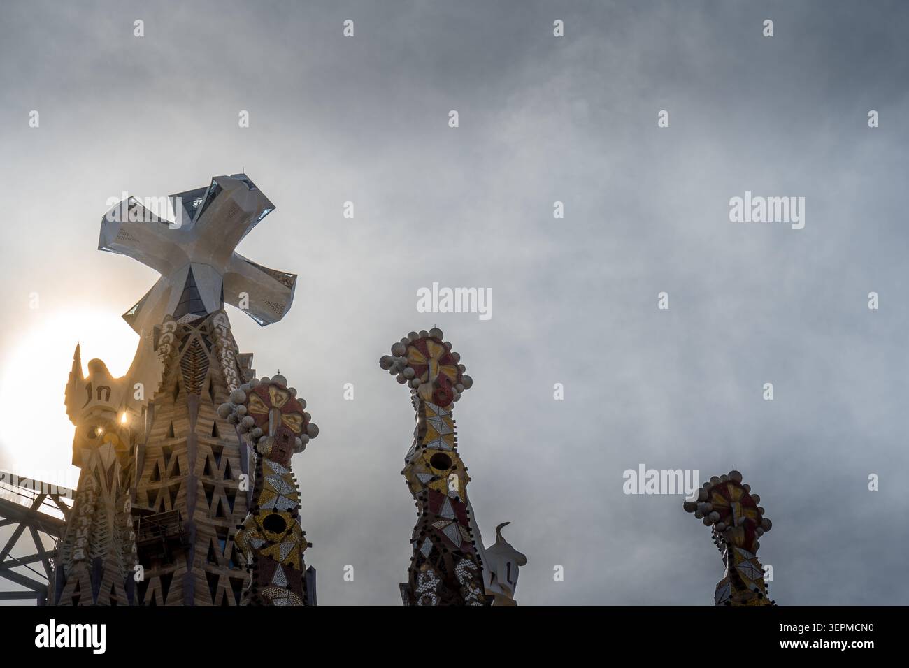 Barcellona, Spagna. 13 giugno 2026, la Sagrada Familia Jesus Tower top cross contro il cielo nuvoloso Foto Stock