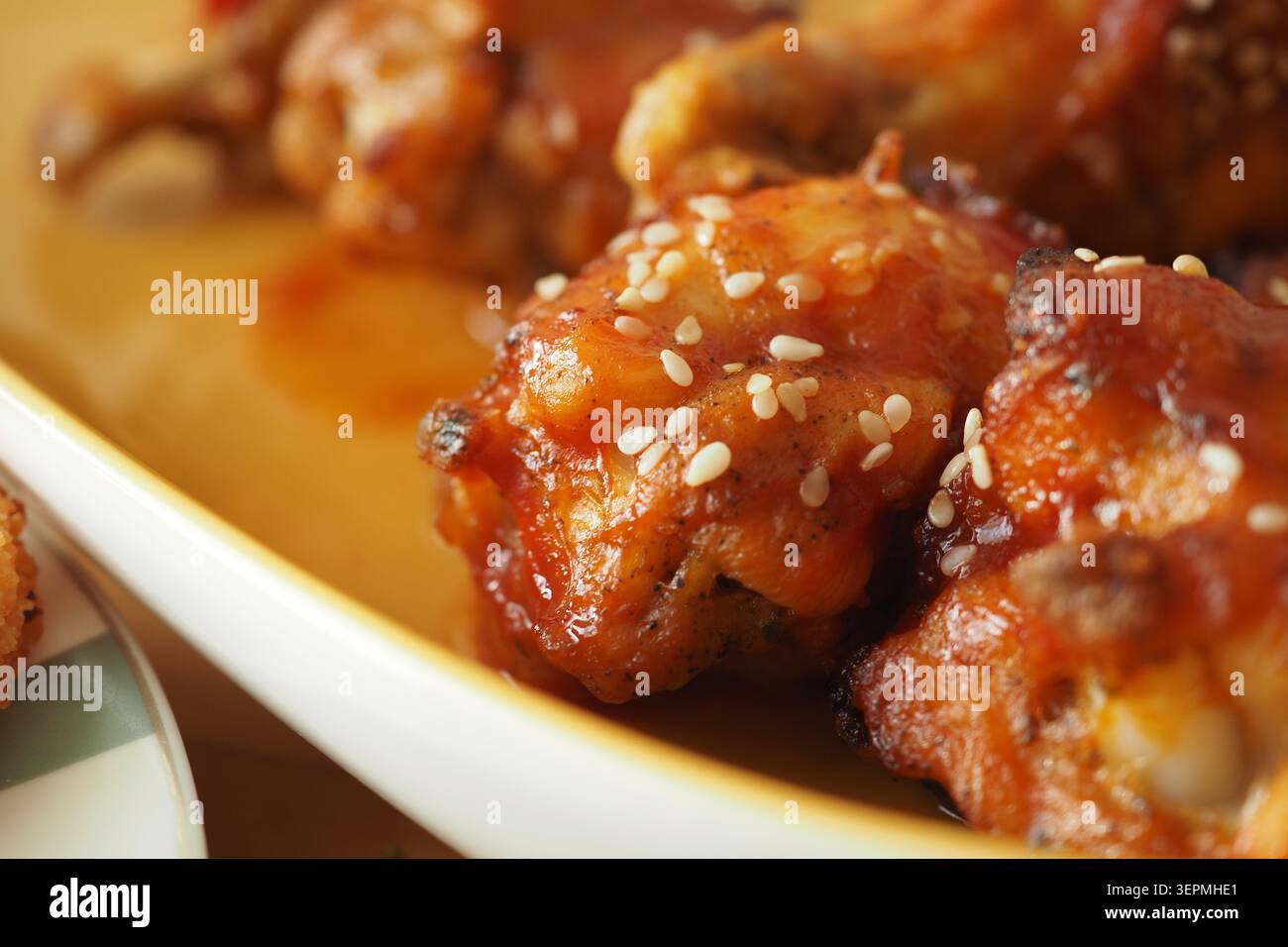 Pezzi di pollo alla griglia serviti con salsa e semi di sesamo Foto Stock