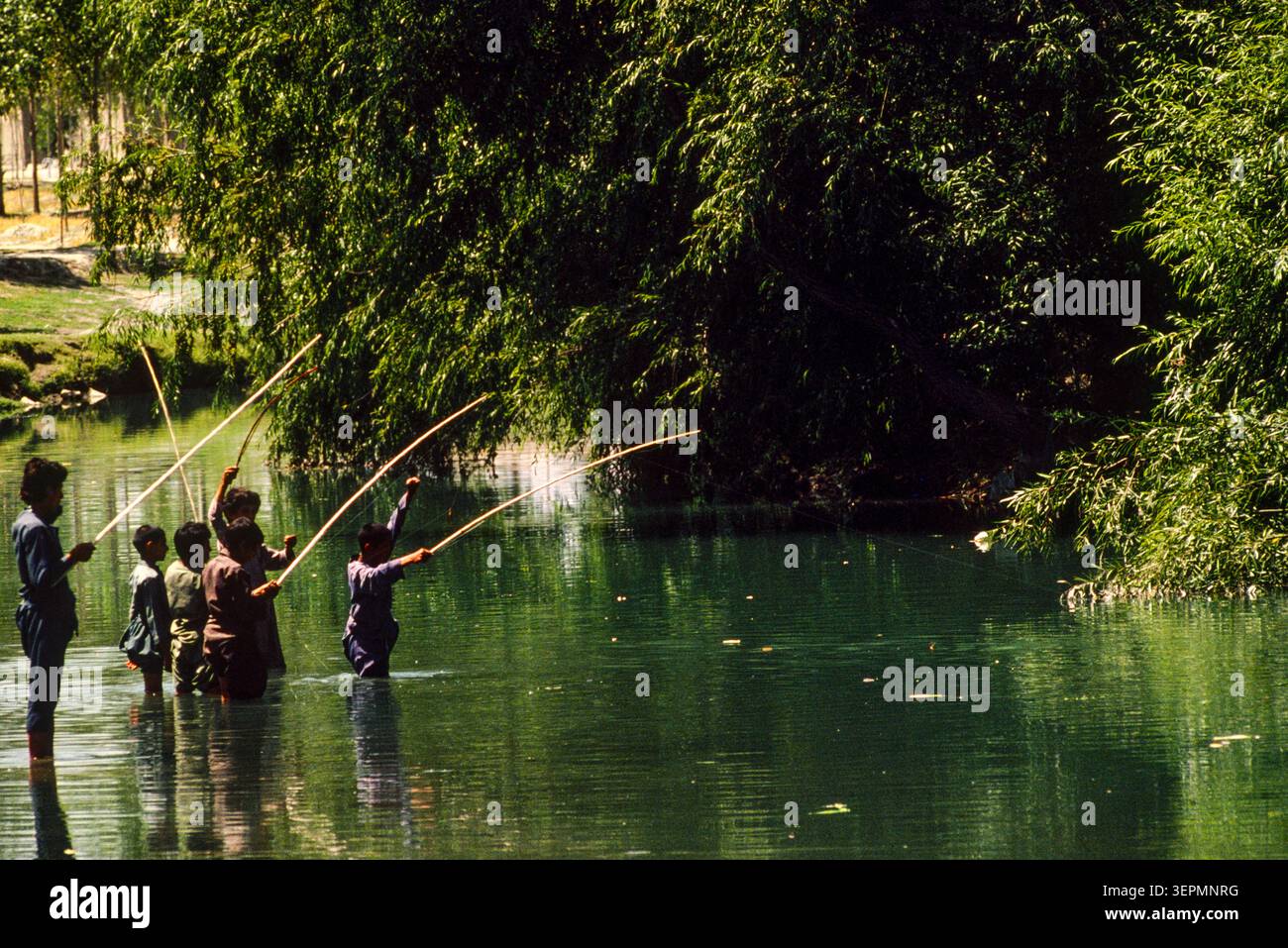 Ragazzi che pescano in un affluente del fiume Kabul, Afghanistan, agosto 1992 Foto Stock