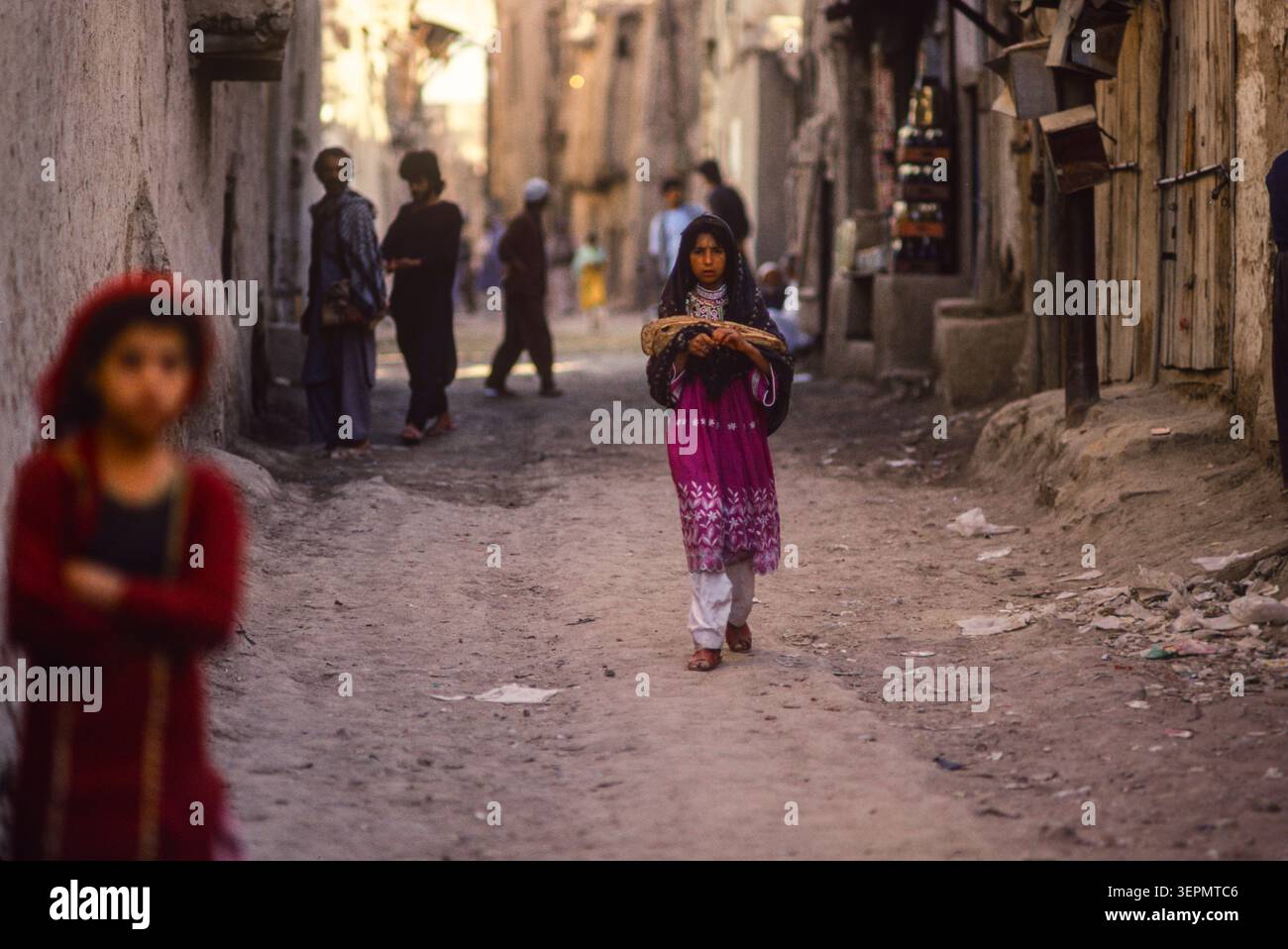 Persone che portano a casa il tradizionale pane naan nelle strade secondarie di Kabul, Afghanistan, agosto 1992 Foto Stock