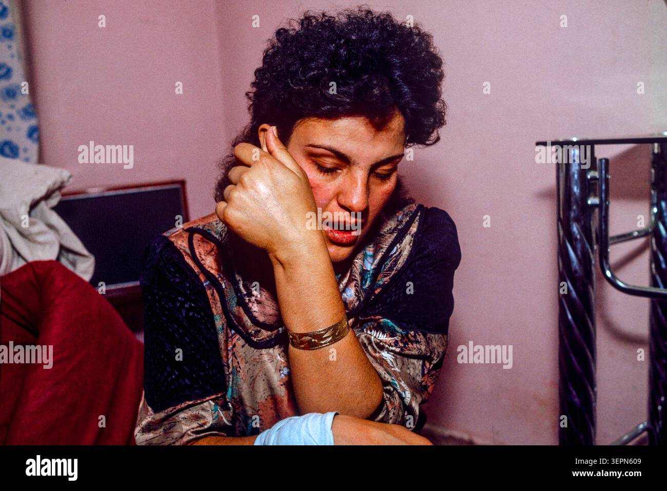 Una giovane donna aspetta di fuggire dalla zona di Karti Sanhi dopo 3 giorni di combattimenti, Kabul, Afghanistan, 1992 Foto Stock