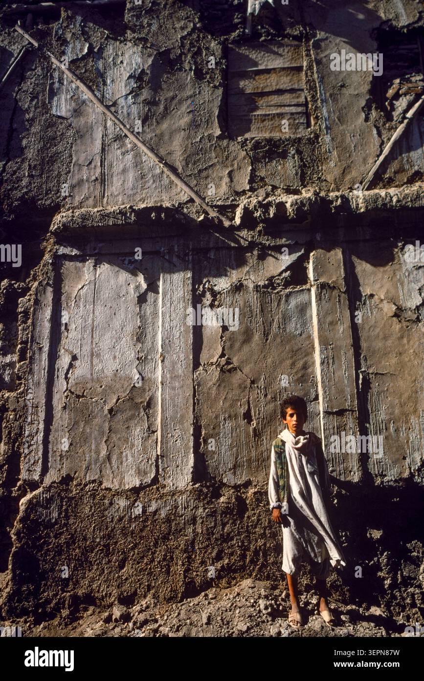 Un ragazzo si trova di fronte a un muro in rovina nella città vecchia, Kabul, Afghanistan, 1992 g. Foto Stock