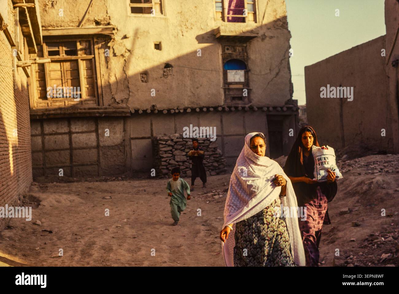 La famiglia TA torna a casa con il tradizionale pane naan ghome nelle strade secondarie di Kabul, Afghanistan, agosto 1992 Foto Stock