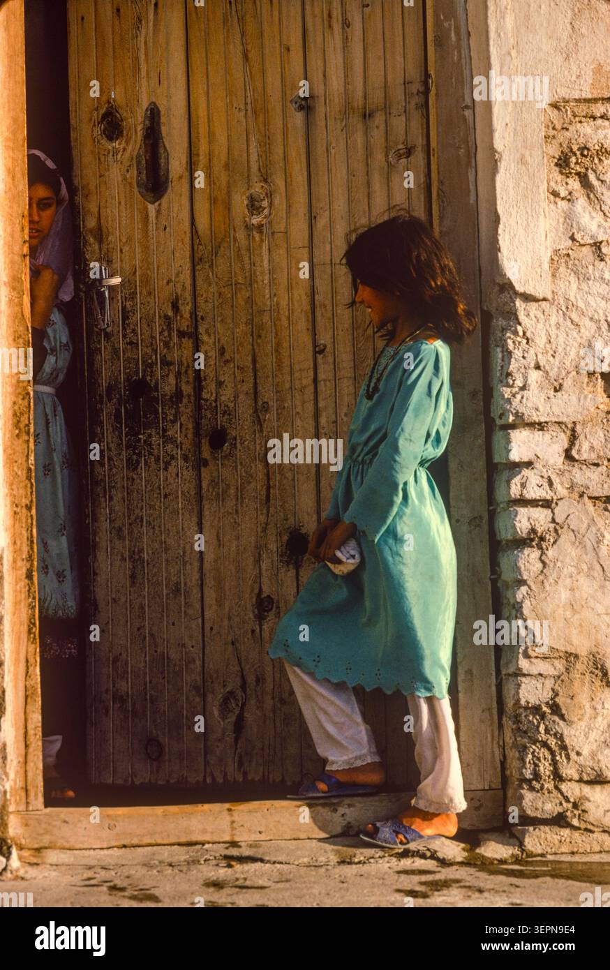 Una ragazza chiama un amico nella città vecchia, Kabul, Afghanistan, 1992 Foto Stock
