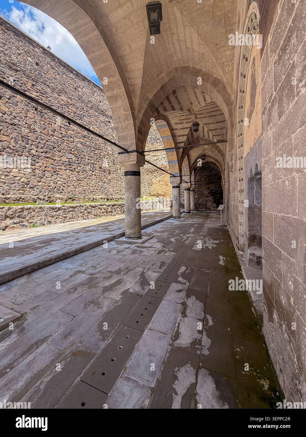 Questa immagine cattura la splendida architettura di un antico corridoio ad arco in Cappadocia, che mostra l'intricata lavorazione in pietra. Foto Stock