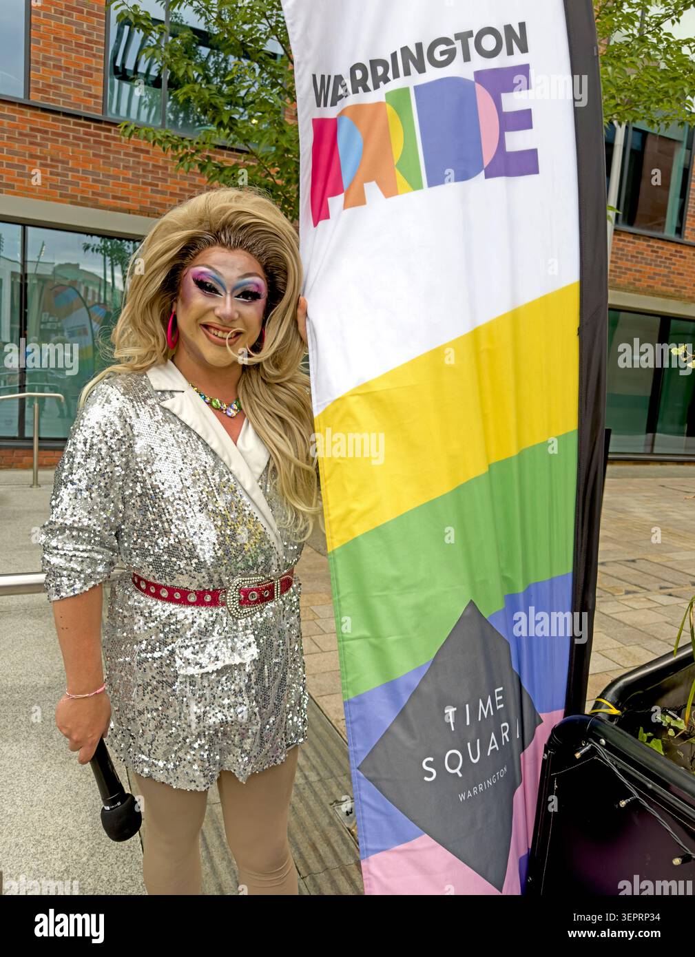 Kiki Inferno in un costume argentato scintillante durante le celebrazioni del Warrington Pride a Time Square, Warrington, il 13 giugno 2026 Foto Stock