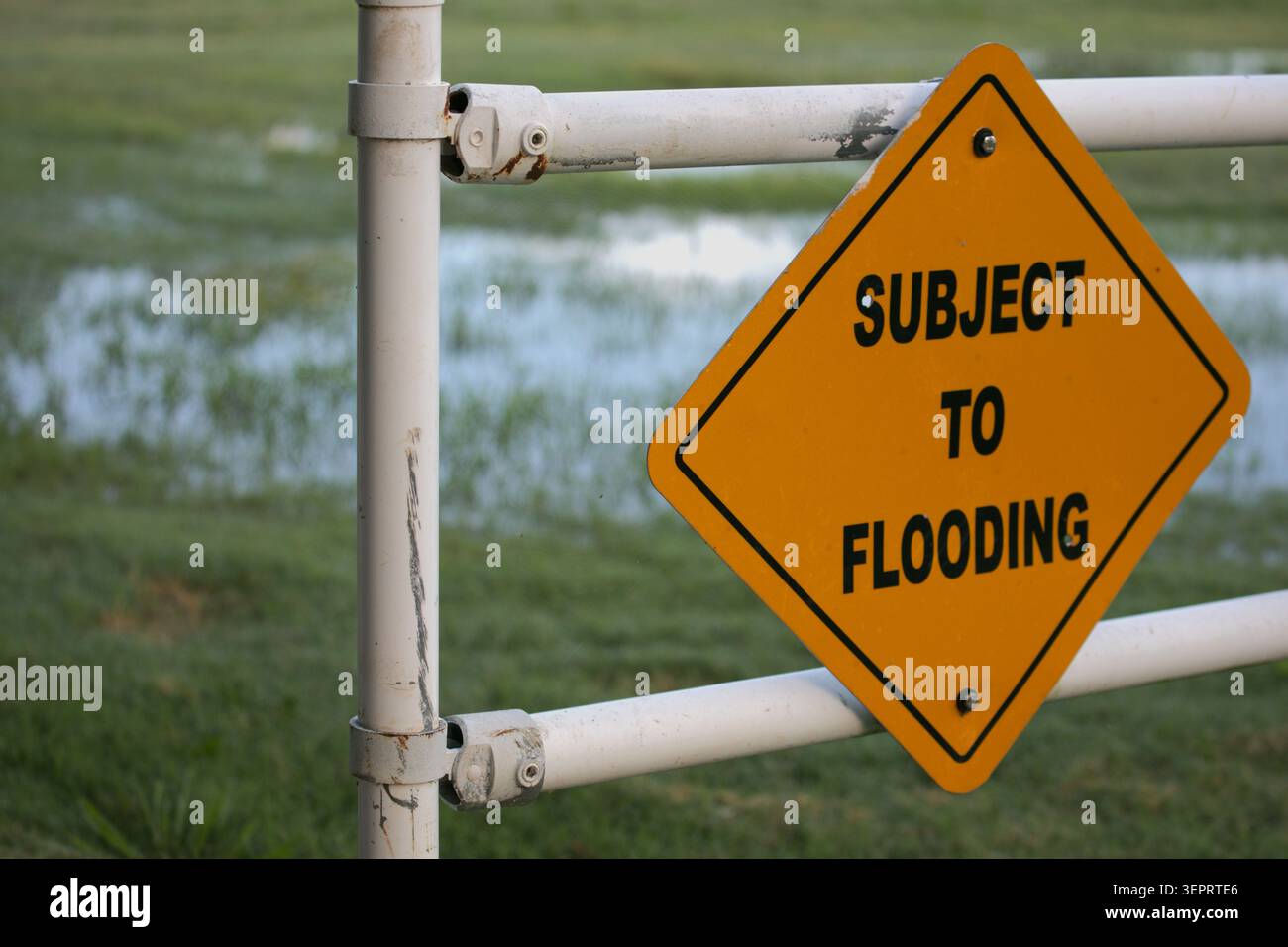Un cartello di avvertenza arancione avverte di allagamento. La FEMA sta rivedendo i confini delle pianure alluvionali, mentre i cambiamenti climatici globali influiscono sui modelli meteorologici. Foto Stock