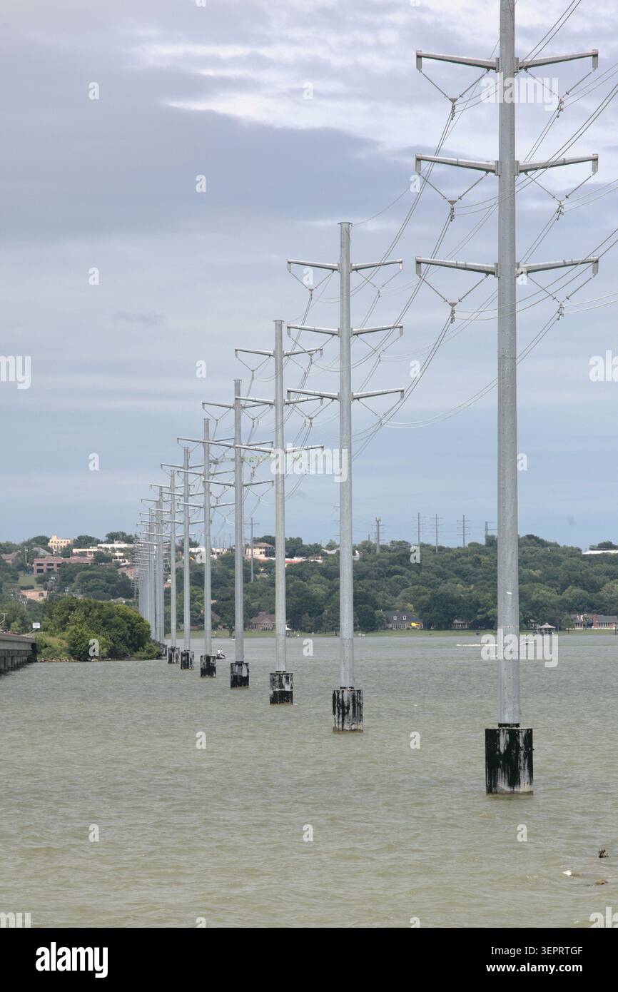 Le linee di alimentazione ad alta tensione attraversano un corpo d'acqua. Le infrastrutture elettriche nazionali stanno invecchiando. Foto Stock