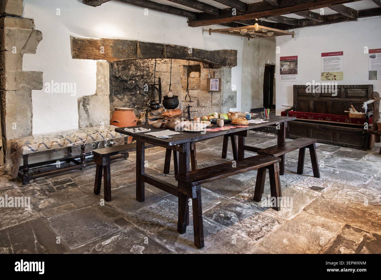 Suggestiva mostra della sala Tudor con travi a soffitto in legno pesante e un caminetto inglenook all'interno del Bakewell Old House Museum Foto Stock