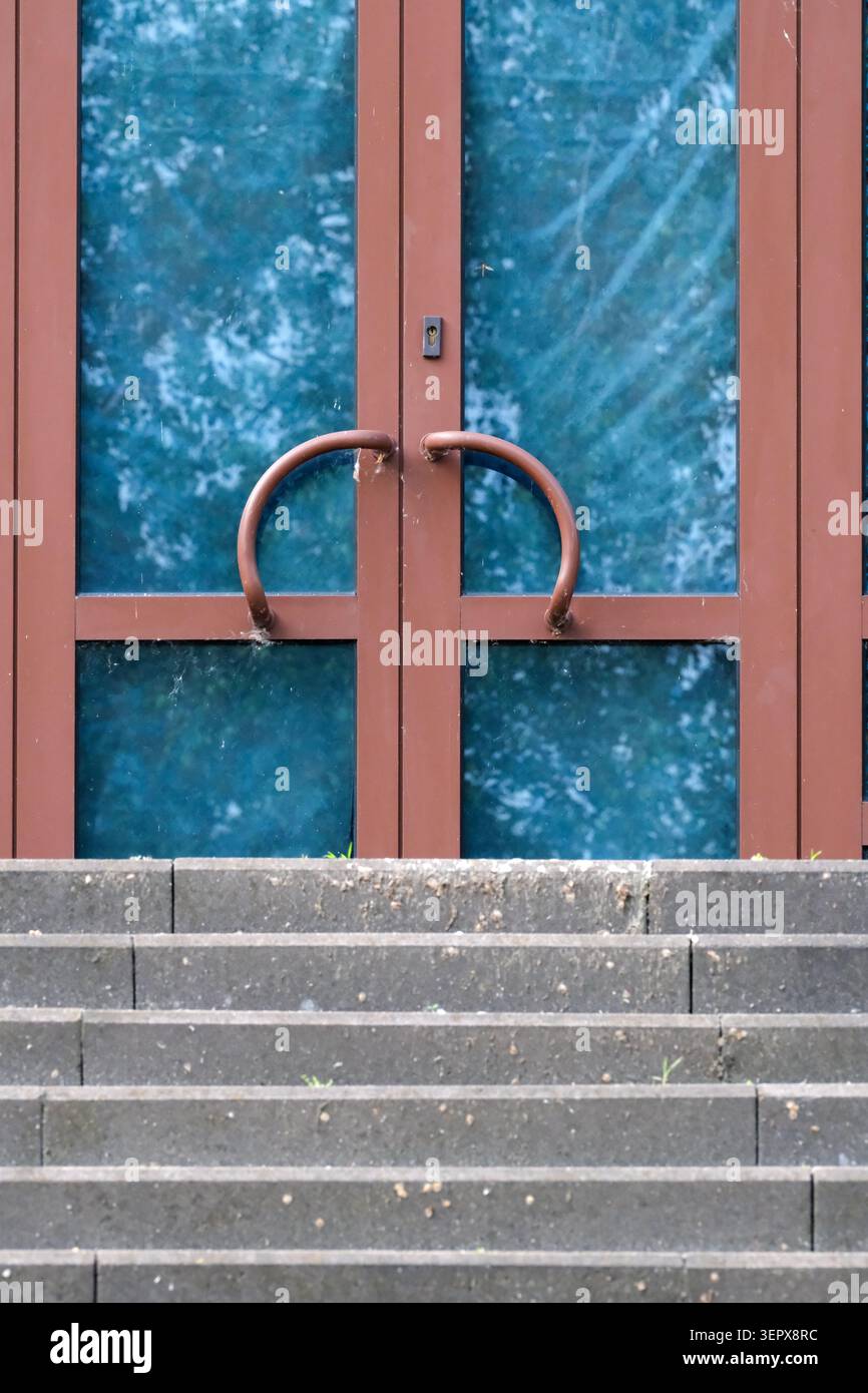 I gradini conducono a un'incantevole porta adornata da maniglie artistiche. Foto Stock