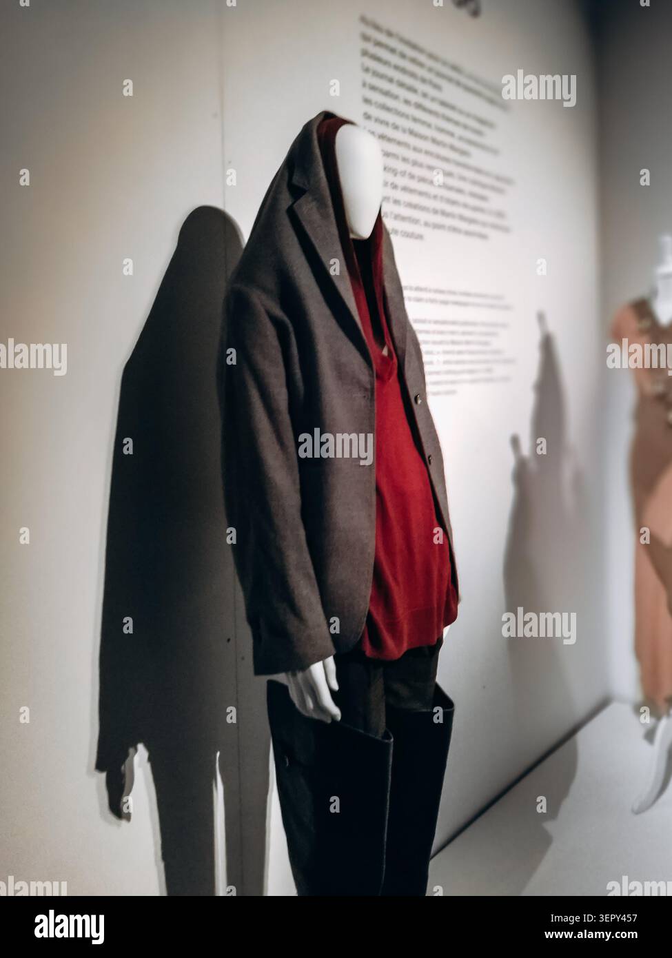 Parigi, Francia - 18 marzo 2018: Manichino con un blazer oversize grigio, top con cappuccio Bordeaux e ampi pantaloni neri esposti al Margiela Gall Foto Stock