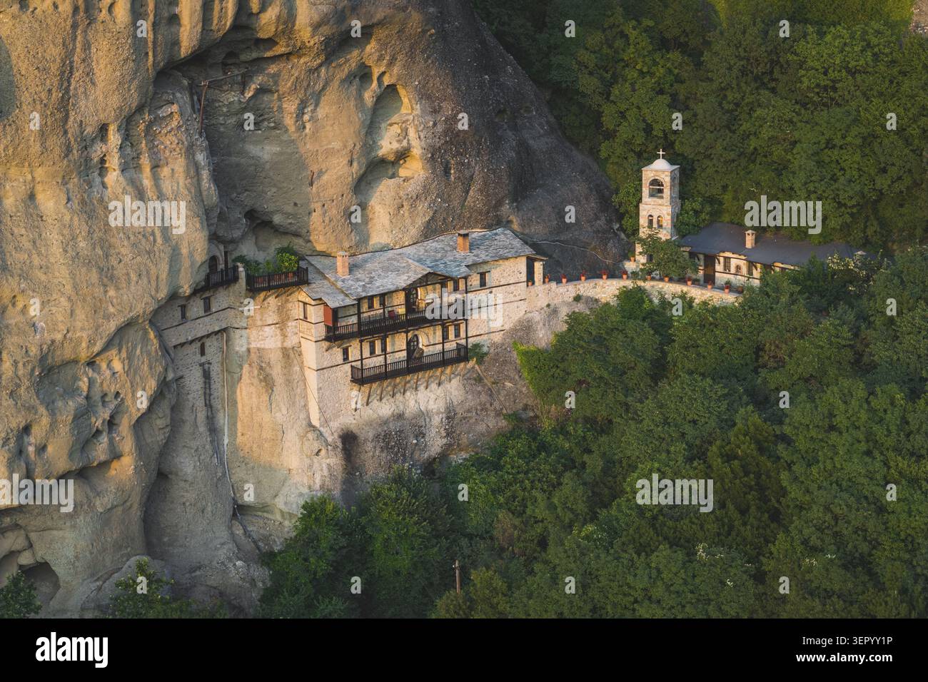 Veduta aerea del Monastero di San Nicola Anapausas costruito in una ripida scogliera rocciosa circondato da una fitta foresta verde a Meteora, Trikala, Grecia. Foto Stock