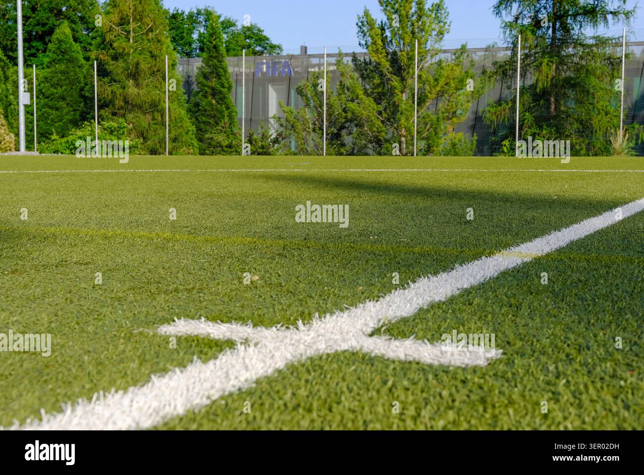 30.05.2026, Svizzera, Canton Zuerich, Zuerich - sede della FIFA, l'edificio isolato della sede centrale sulla Z¸richberg dietro un campo da calcio; nel fo Foto Stock