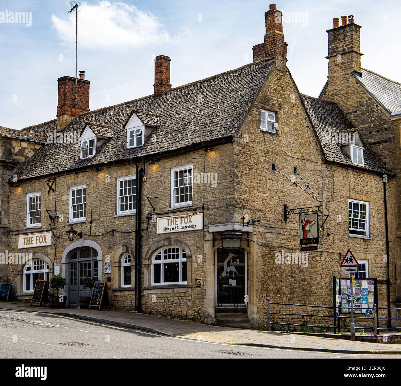 Facciata storica in pietra del pub Fox e sistemazione nella pittoresca cittadina inglese di Chipping Norton durante il giorno Foto Stock