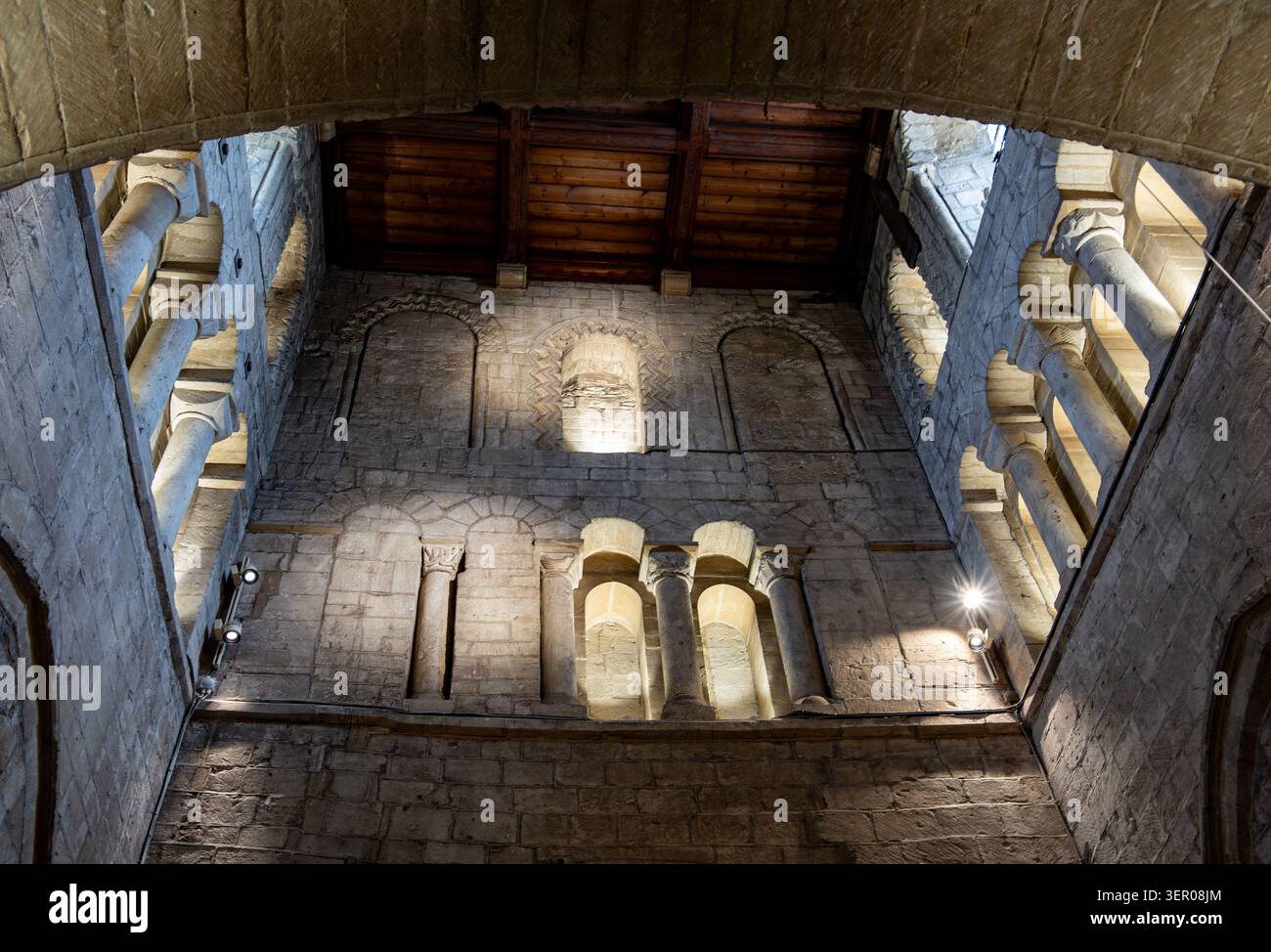 Vista ad angolo basso delle pareti interne in pietra e del soffitto in legno dell'antica torre di St John the Baptist Church a Burford, Oxfordshire Foto Stock
