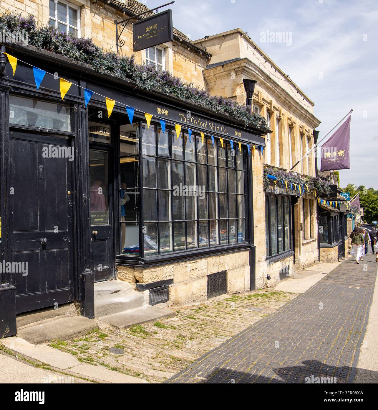 Edificio tradizionale in pietra con un classico ripiano per la Oxford Shirt Co e su una strada tranquilla nella città di Burford nell'Oxfordshire Foto Stock