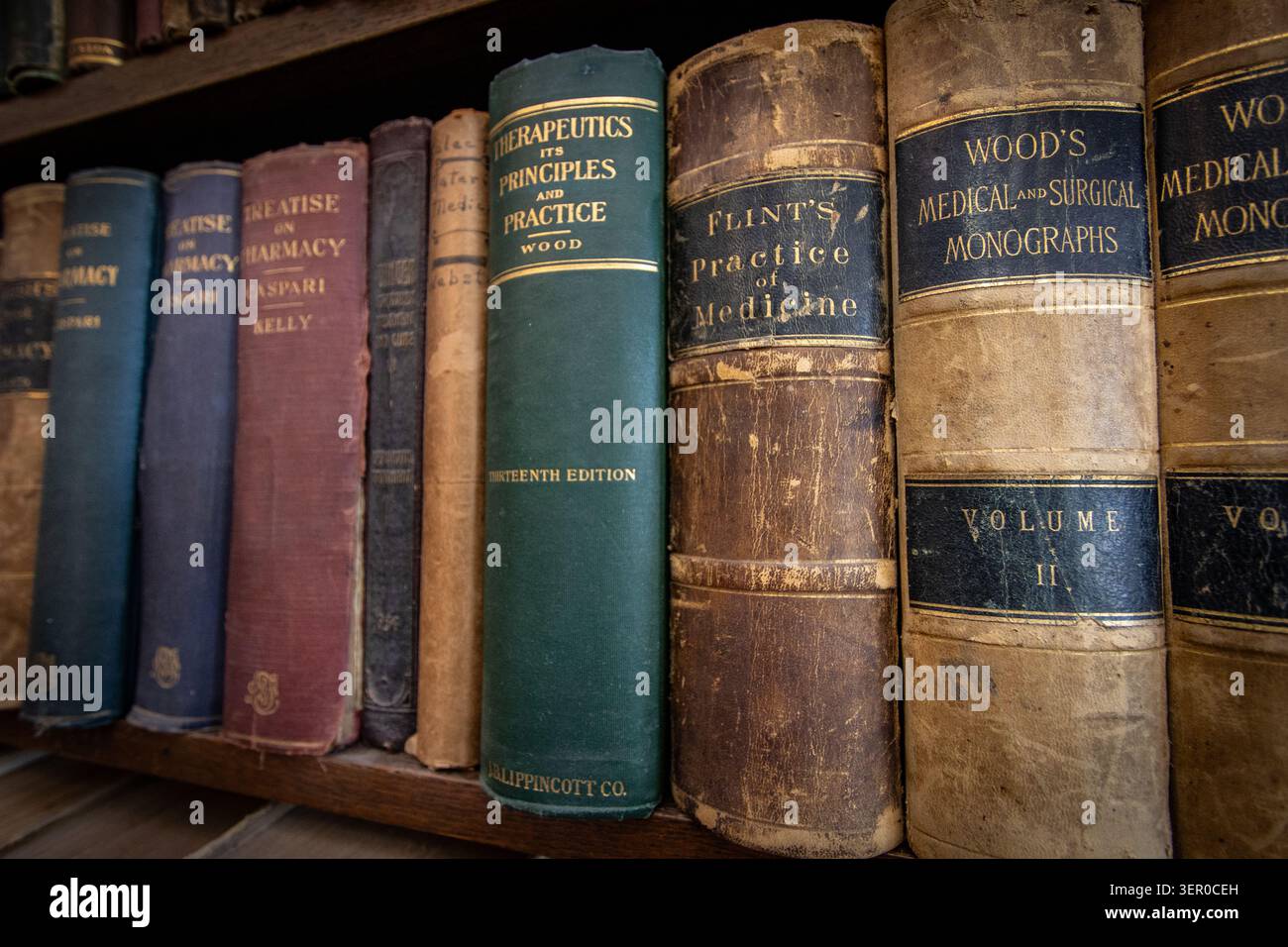 Libri di medicina antichi disposti su uno scaffale della biblioteca Foto Stock
