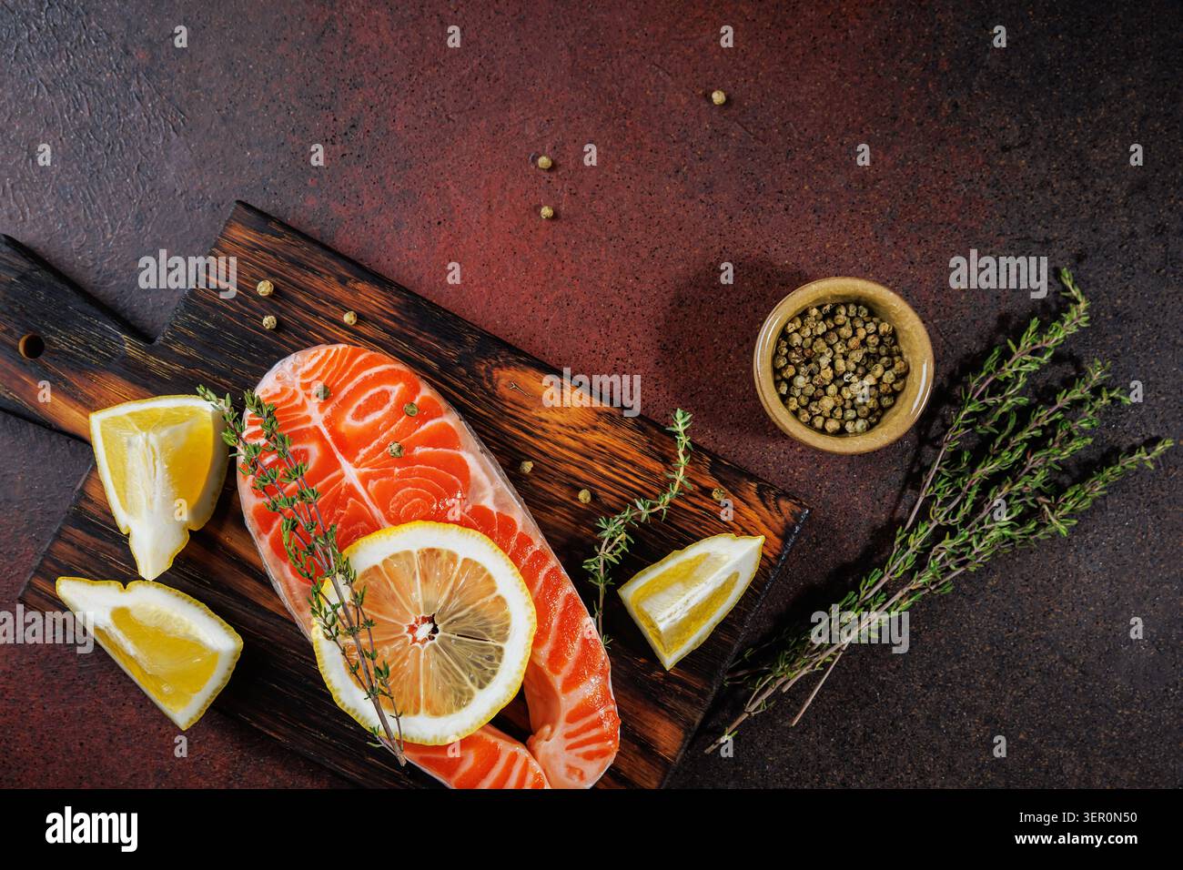 Salmone crudo con erbe aromatiche e grani di pepe rustico in stile cucina Foto Stock