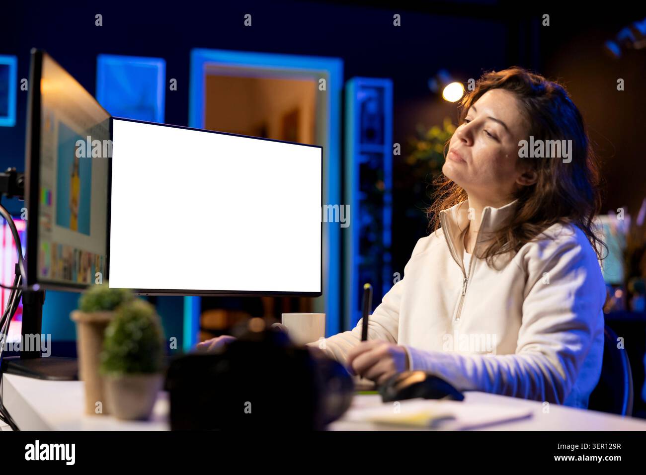 Il fotografo utilizza un software di fotoritocco sul display del PC mockup nello studio personale. Freelancer utilizza un programma di ritocco fotografico su un computer multi-monitor a schermo isolato. Foto Stock