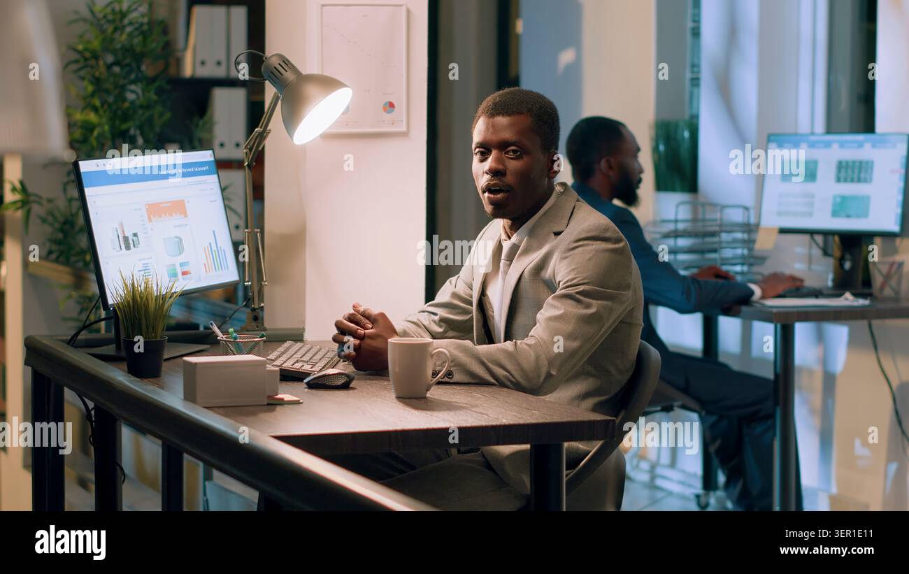 Manager afroamericano che fa video di formazione in ufficio per i nuovi dipendenti. Foto Stock