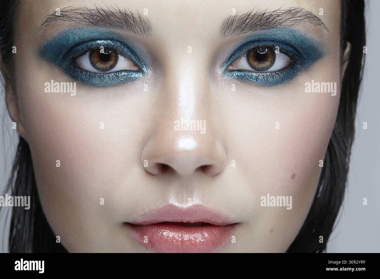 Macro Closeup ritratto di volto femminile. Donna con la sera la bellezza del trucco. Ragazza con una pelle perfetta e blu-verde smoky occhi occhio ombre Foto Stock