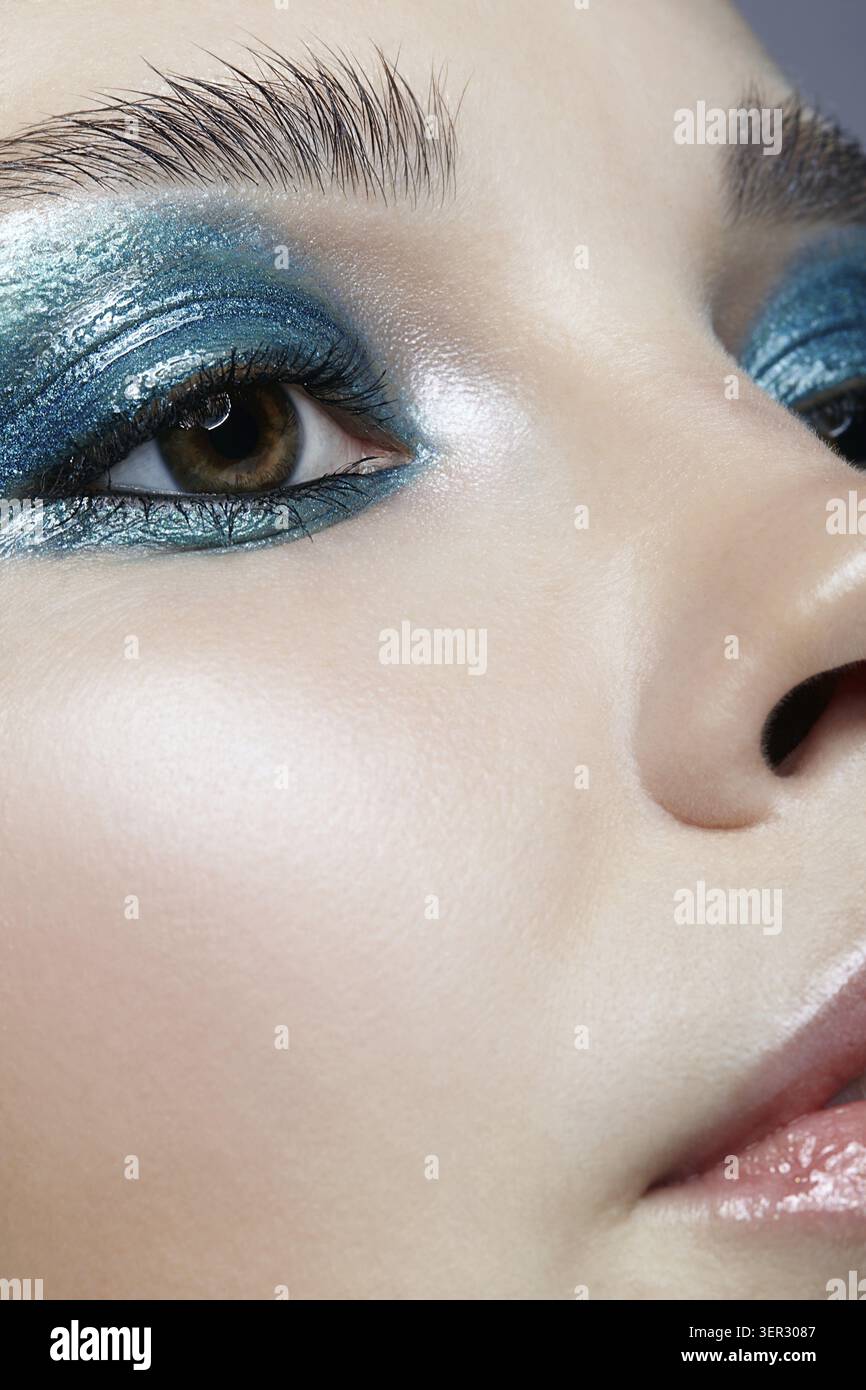 Macro Closeup ritratto di volto femminile. Donna con la sera la bellezza del trucco. Ragazza con una pelle perfetta e blu-verde smoky occhi occhio ombre Foto Stock