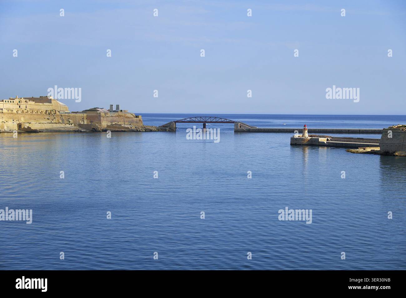 La vista dell'accesso al Grand Harbour con St. Elmo bastione, nuovo ponte di frangiflutti e il faro Ricasoli, Malta Foto Stock