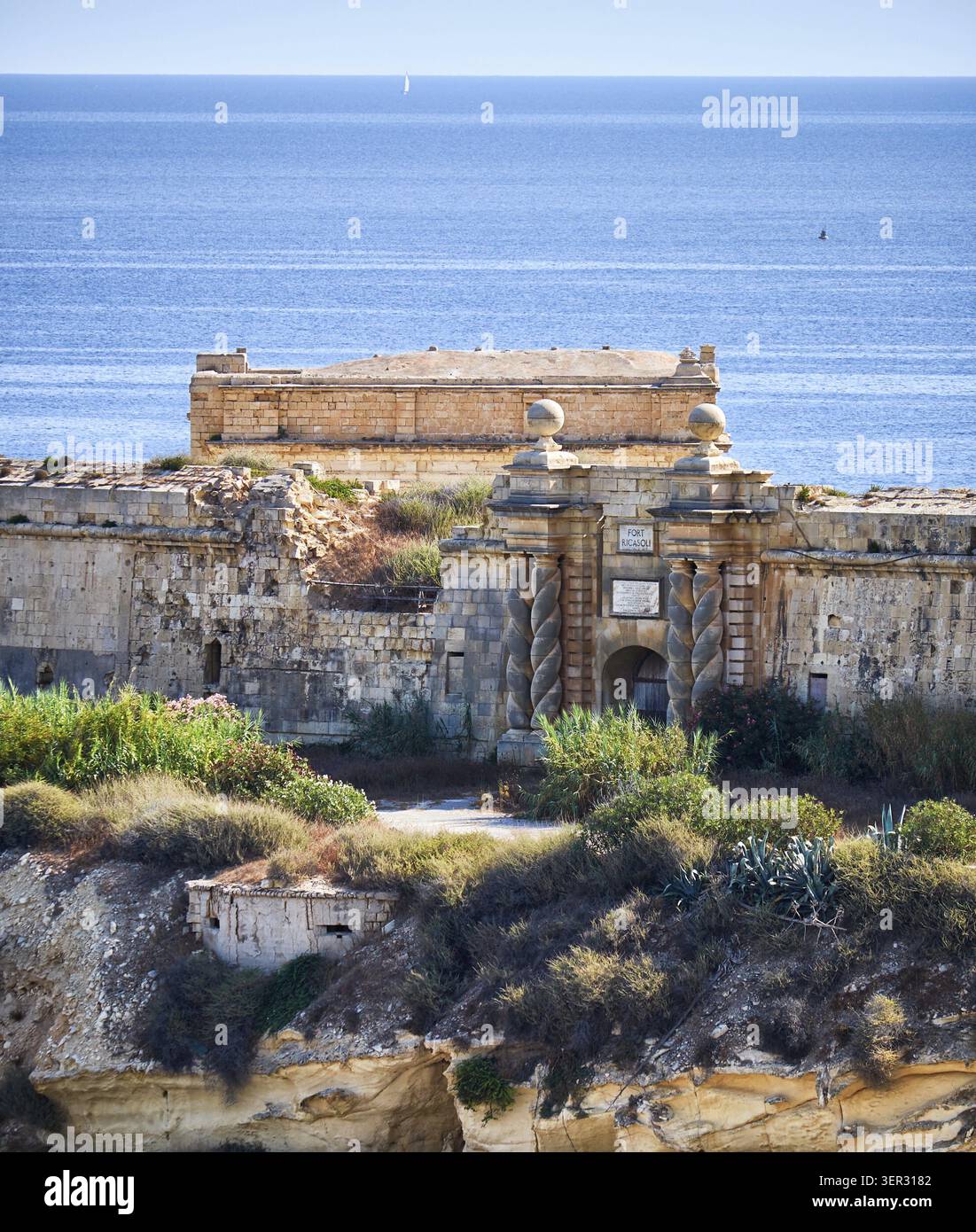 La porta sud di Fort Ricasoli con le famose trecce formano delle cocche come si vede da Kalkara sopra la baia di Rinella, Kalkara, Malta Foto Stock