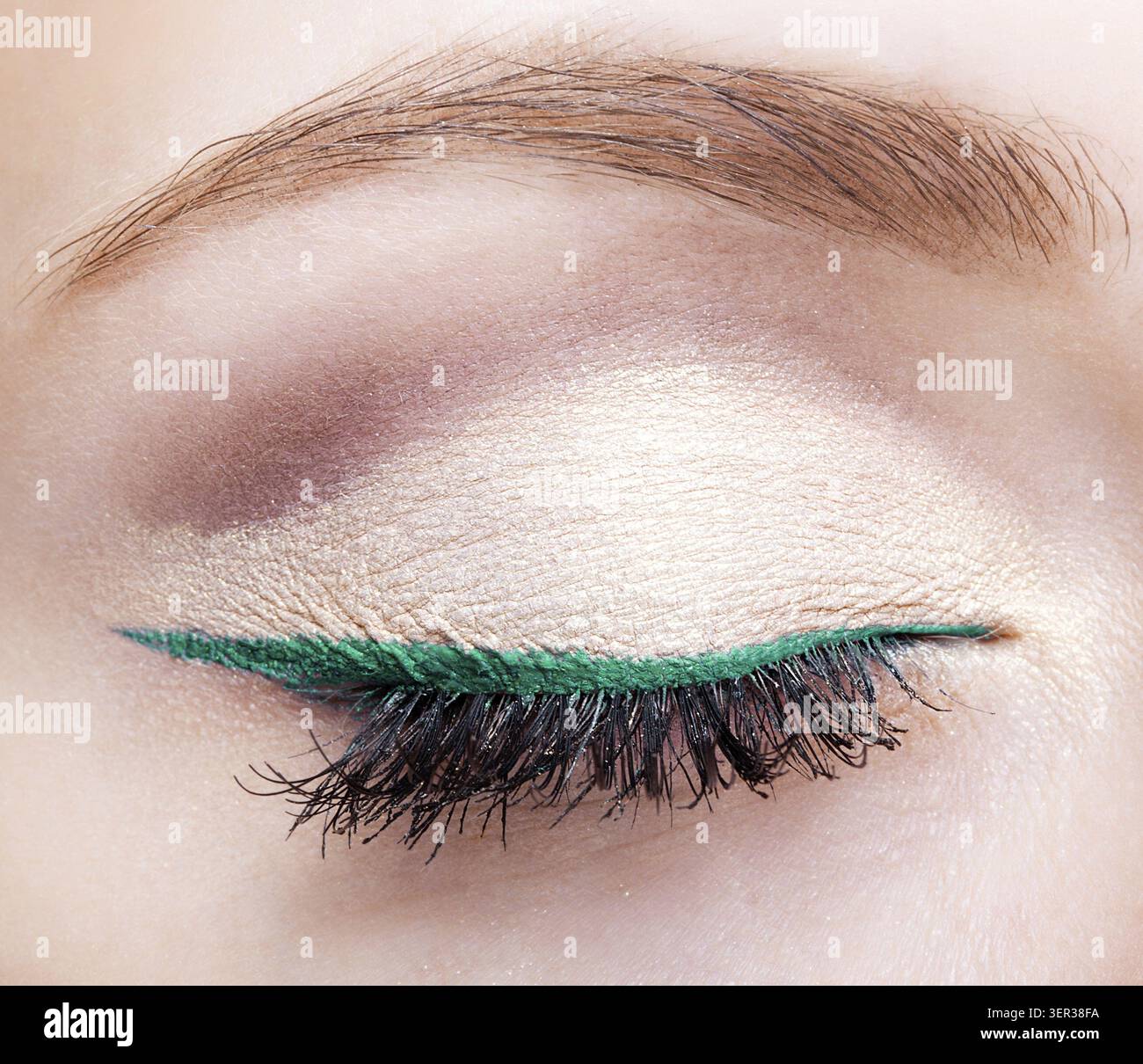 Closeup colpo di volto femminile di trucco con gli occhi chiusi e eyeliner verde Foto Stock