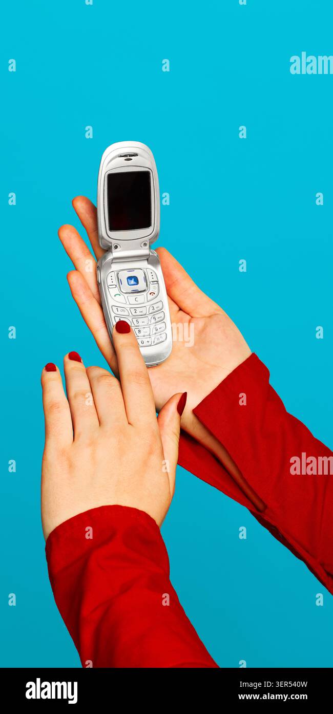 Donna che chiama un cellulare vintage con maniche rosse su sfondo blu. Foto Stock