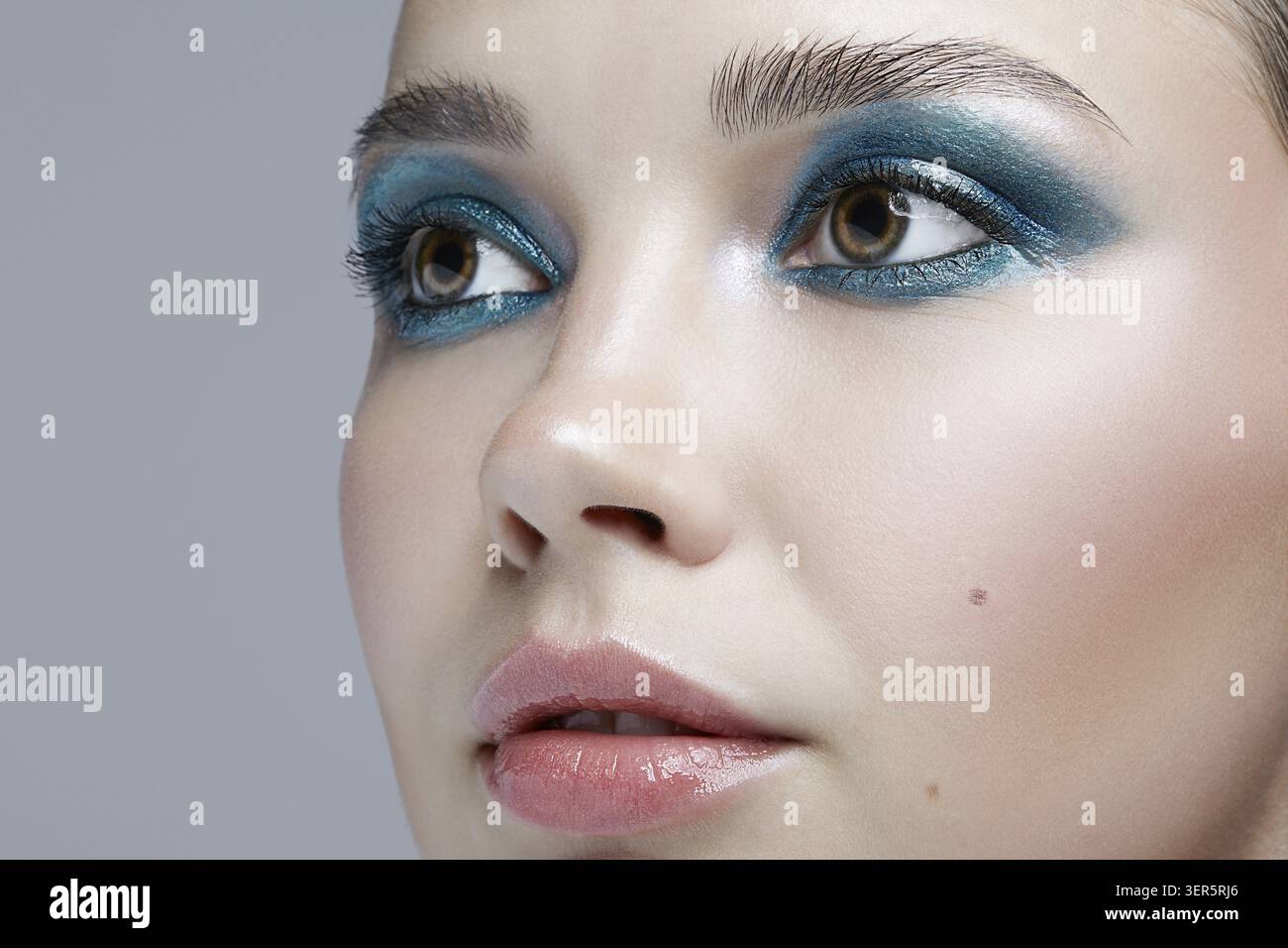 Macro Closeup ritratto di volto femminile. Donna con la sera la bellezza del trucco. Ragazza con una pelle perfetta e blu-verde smoky occhi occhio ombre Foto Stock
