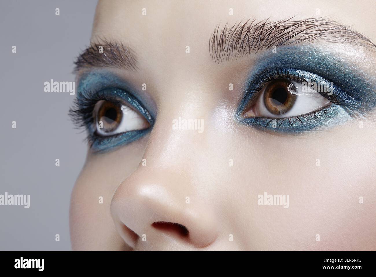 Primo piano macro di occhio umano femminile. Donna con trucco naturale per la sera. Ragazza con pelle perfetta e occhi fumé blu-verdi Foto Stock